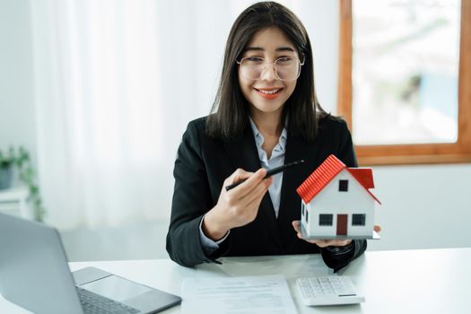 Law, agreement, contract, mortgage, woman holding a pen, pointing at a house to see the interest rate and asking for the limit to assess the risk before buying a house