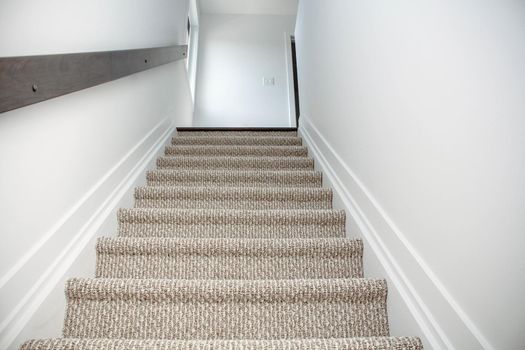 Top view of Staircase in the modern house with brown carpet, walk through ground floor