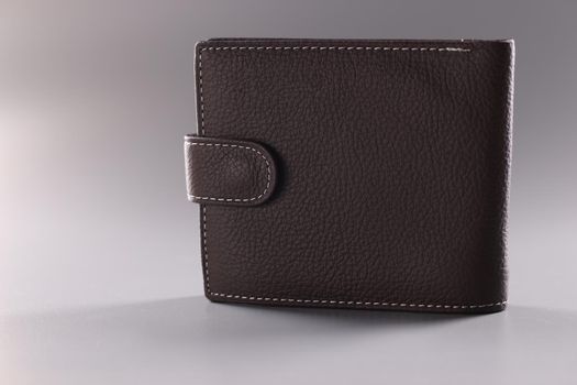 Brown leather wallet with button, full of banknotes and credit cards inside