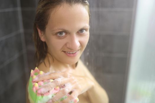 Young woman take hot shower after hard day, cleansing with washcloth