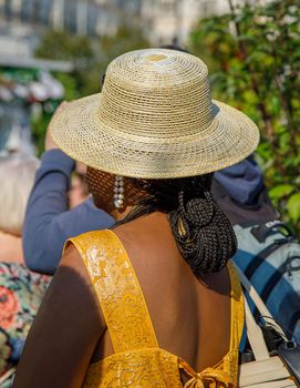 A black woman in a straw hat takes shelter from the sun