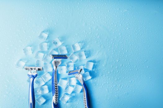 Three shaving machines on a frosty blue background with ice. The concept of cleanliness and frosty freshness