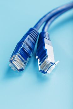 Two Ethernet Cable Connectors Patch cord cord close-up isolated on a blue background with free space