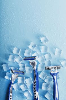 Three shaving machines on a frosty blue background with ice. The concept of cleanliness and frosty freshness