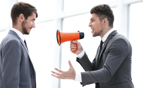 aggressive businessman with megaphone screaming on his coworker, isolated on white