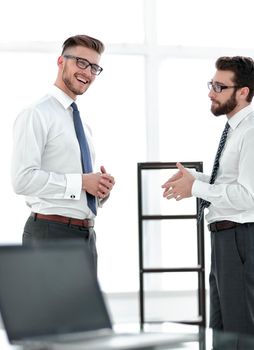 two businessmen talking standing in the office