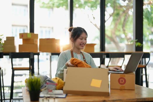 Startup small business entrepreneur SME, asian woman packing box. Portrait of young Asian small business owner in home office, online sell marketing delivery, SME e-commerce telemarketing concept
