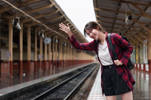 Beautiful traveler with backpack go to summer trip by train. Travel concept.