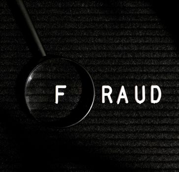 fraud word with letter magnifying glass top view