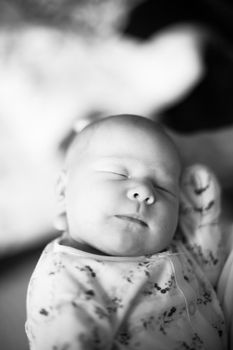 black and white photo in retro style.a pretty sleeping newborn baby