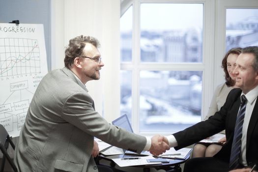friendly handshake of business partners in the office