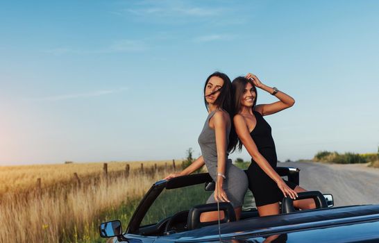 Beautiful two women sitting in a convertible