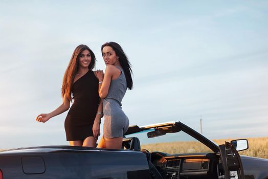 Two women in a black car on the roadside roads