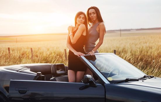 Two women in a black car on the roadside roads