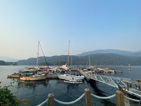 Sailboats at a marina with mountains in the background and blue skies