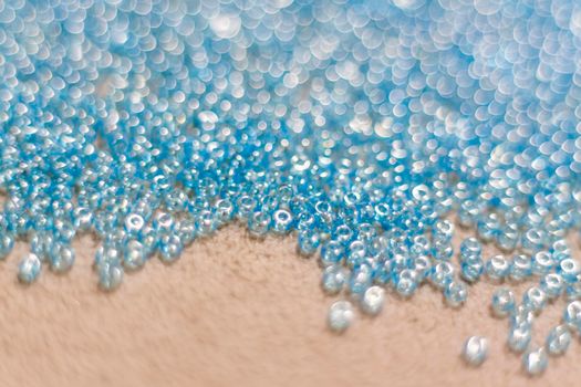 small blue beads lie scattered on the textile surface