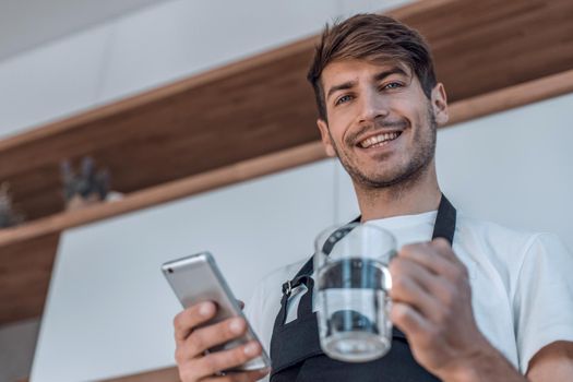 attractive young man reading a recipe on his smartphone