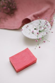 Natural handmade soap bar with ceramic soap dish and flowers, spa organic soap, sustainable lifestyle