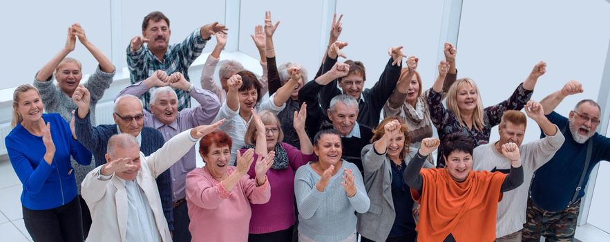 group of elderly friends raised their hands up and celebrate suc