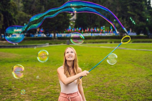 Happy carefree young woman blowing soap bubbles