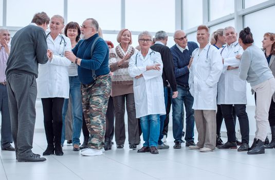 Group Of Mature People And Doctors Indoors Full Length