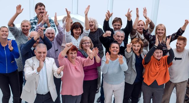 group of mature friends raised their hands up and celebrate succ