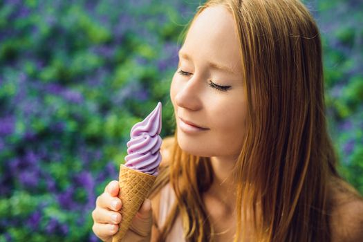 Young woman eats lavender ice cream on a lavender field background