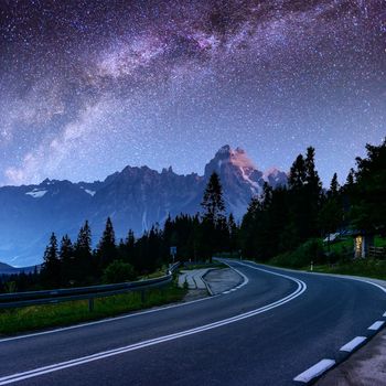 Starry Sky over the mountains. The asphalt road