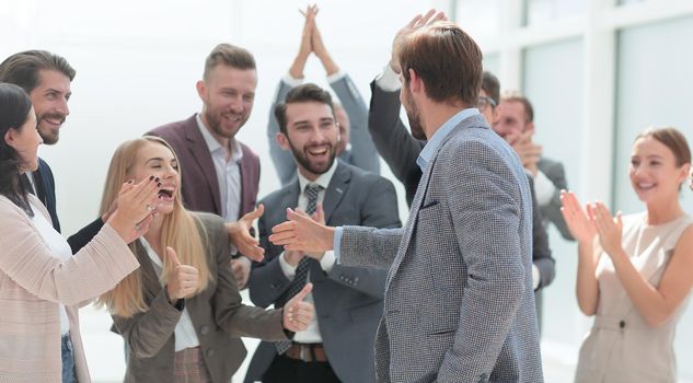 cheerful employees congratulating a colleague on the promotion