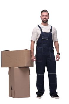 in full growth. smiling man standing near cardboard boxes