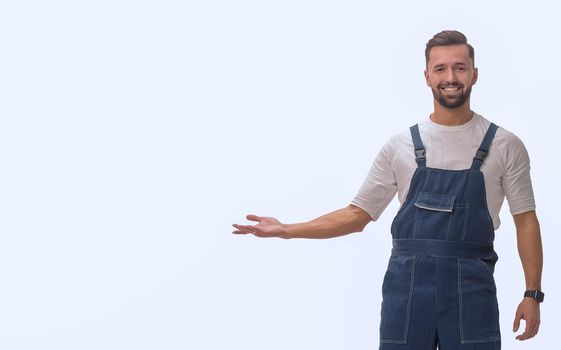 friendly man in overalls pointing to a copy of the space. isolated on white