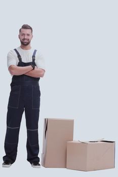 serious man in overalls standing near the boxes. isolated on white