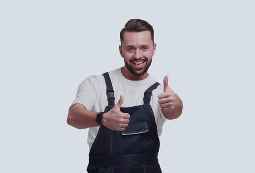 in full growth. friendly man in overalls showing thumbs up