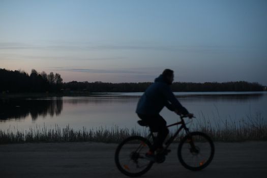 Silhouette of a bicyclist on the beach at sunset