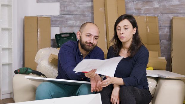 Angry girlfriend hitting boyfriend with furniture instructions