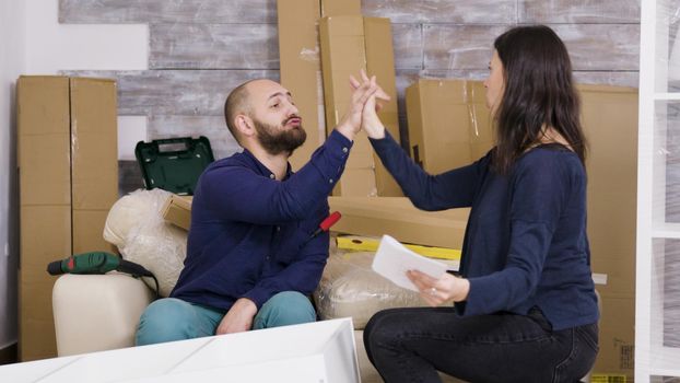 Couple reads instructions for assembly of furniture in new house
