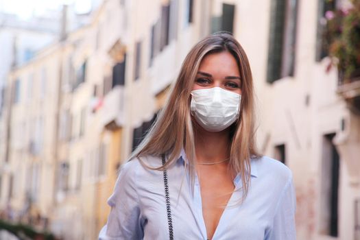 Beautiful tourist woman with corona virus mask at the island of Venice in Italy