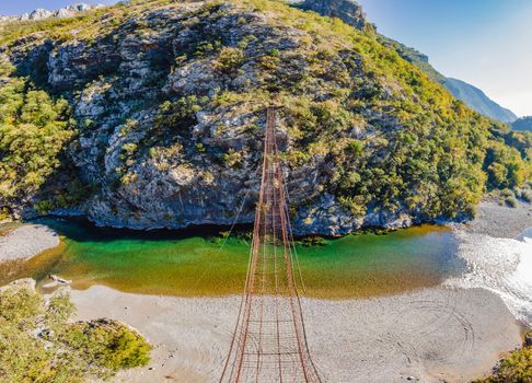 Sights of Montenegro. Landmark Old rusty bridge. Attraction Long extreme suspension iron bridge across the river Moraca. Montenegro