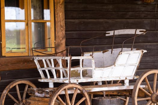 An empty antique carriage stands on a ranch in the wild West