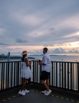 View from the terrace of the Hilton Sky Bar at sunset. Pattaya rooftop bar Thailand, couple man and women watching sunset from a rooftop bar