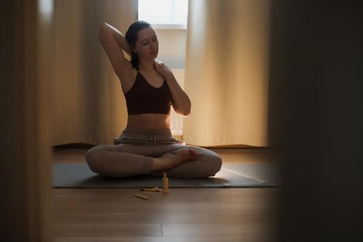 young woman doing yoga and practising meditation at home. meditation and mental health concept