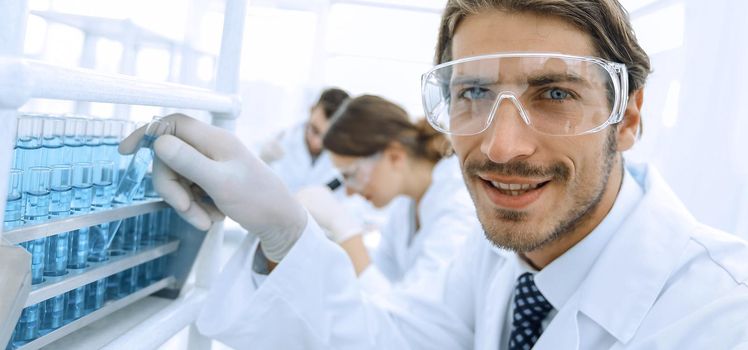close-up of a happy male scientist wearing safety glasses
