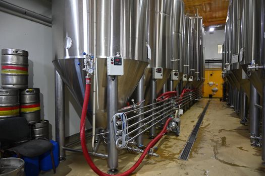 Photo side view of large containers with beer at the beer production