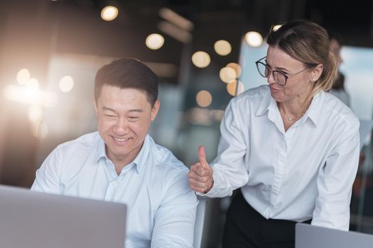 Picture of excited happy emotional colleagues in office working with computer at office