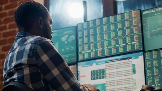 Bank trader analyzing stock market statistics on multi monitors