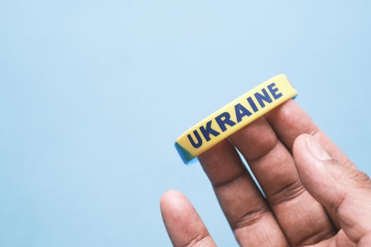 Hand with blue and yellow wristband , colors of flag of Ukraine.