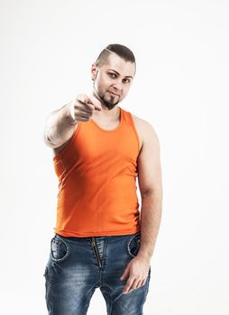 portrait of a sporty guy - bodybuilder in jeans and orange t-shi