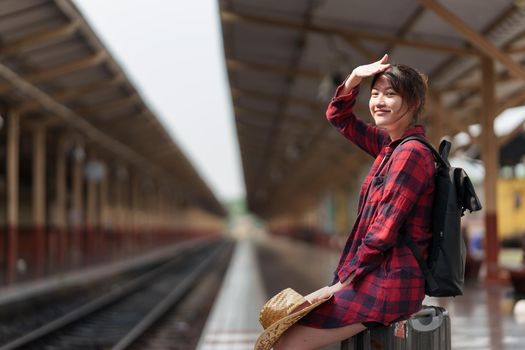 Young traveler woman planning trip at train station. Summer and travel lifestyle concept.
