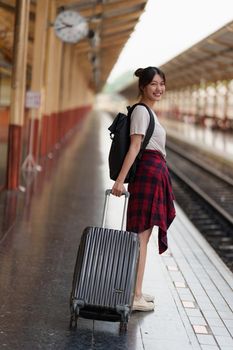 Young traveler woman planning trip at train station. Summer and travel lifestyle concept.