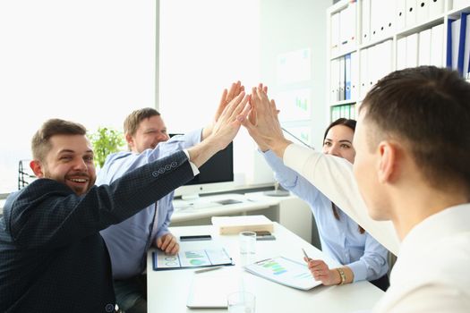 Colleagues give high five in order to celebrate successful contract, good news
